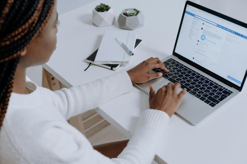 A woman engaging with social media on a laptop in a modern workspace.