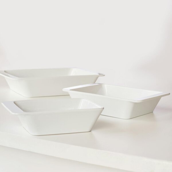 Three clean, white ceramic trays placed on a white surface in a minimalist style.